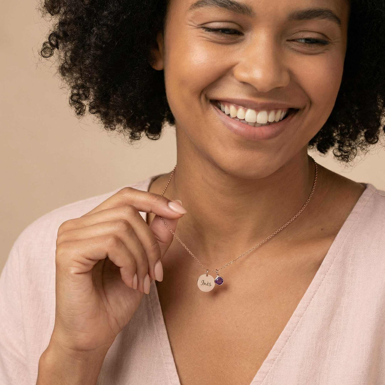Woman wearing Precious Name Necklace with personalized charm and birthstone crystal.