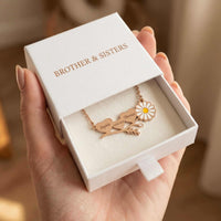 Thumbnail for Daisy Name Necklace in a gift box from Brother & Sisters, featuring engraved names and a delicate white enamel daisy.