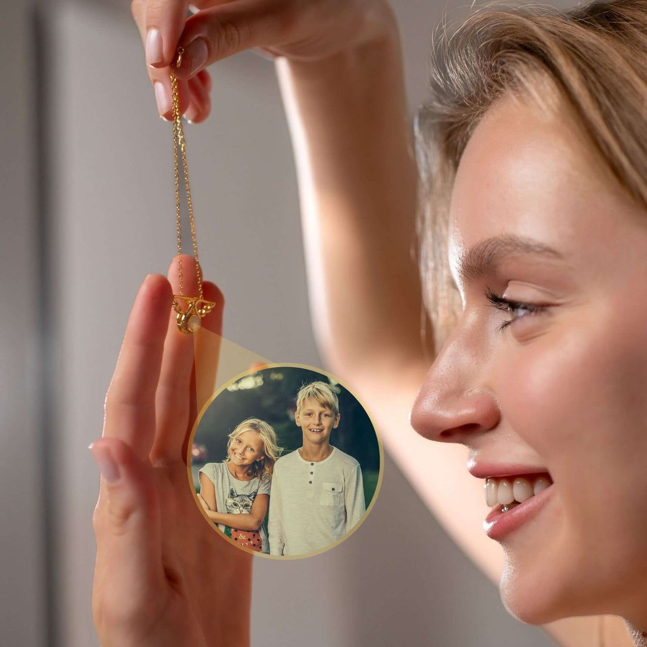 Angel Photo Bracelet held by a woman featuring a personalized photo of two children, showcasing its heartfelt design.
