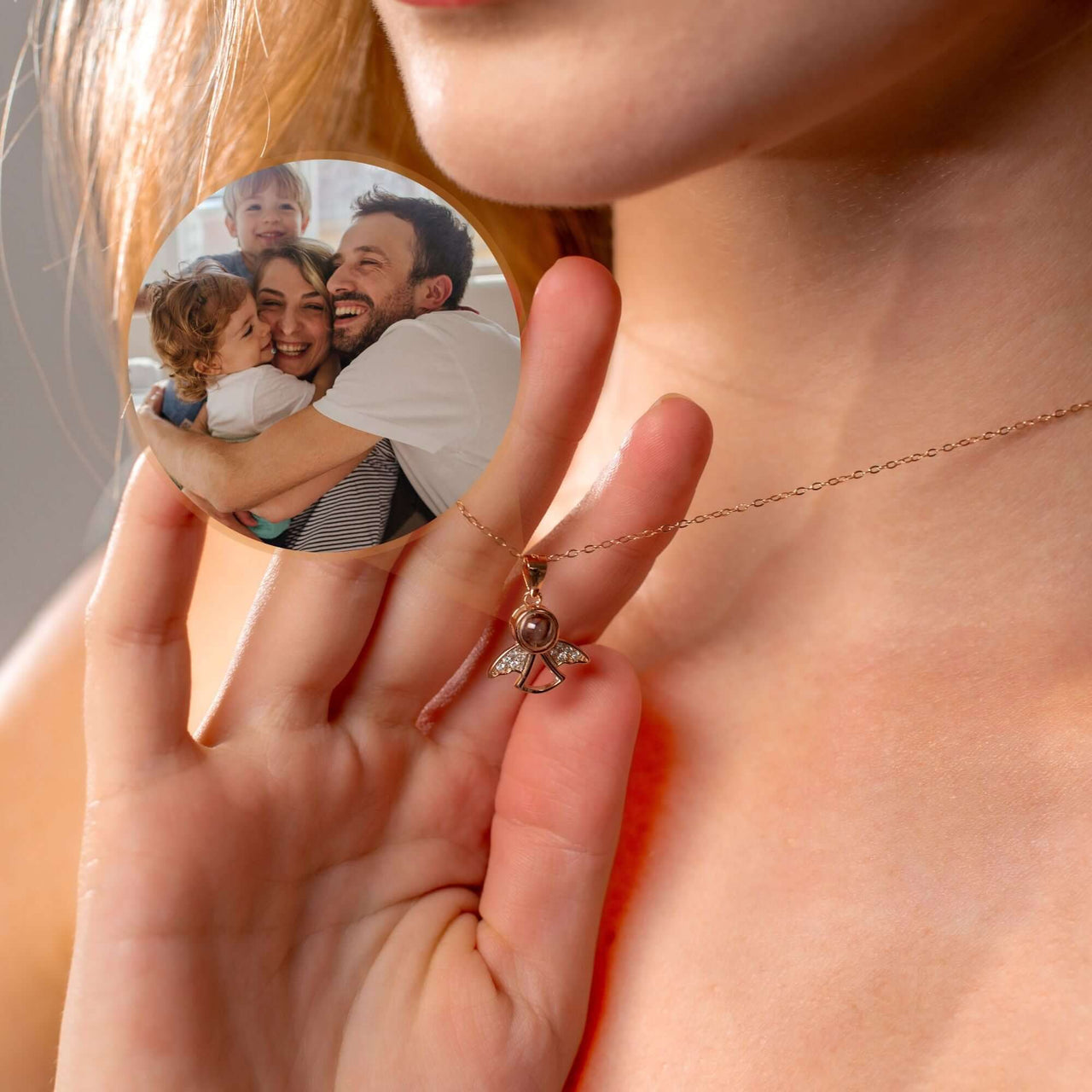 Woman holding an Angel Photo Necklace with a family photo, designed by Brother & Sisters, showcasing elegant angel wings.