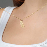 Thumbnail for Baby Bottle Name Necklace featuring a gold bottle-shaped pendant on a delicate chain by Brother & Sisters.