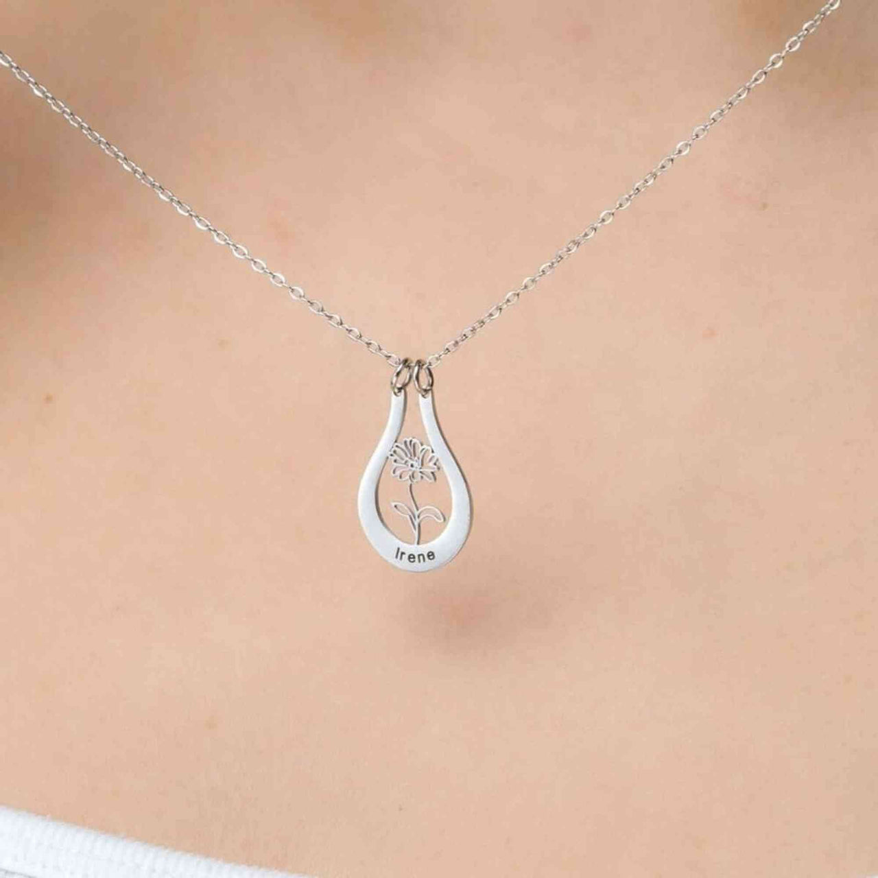 Birth Flower Name Necklace by Brother & Sisters featuring a silver pendant with the name Irene and a flower design.