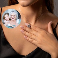 Thumbnail for Double Heart Photo Necklace featuring a woman wearing the necklace while showcasing a personalized photo projection.