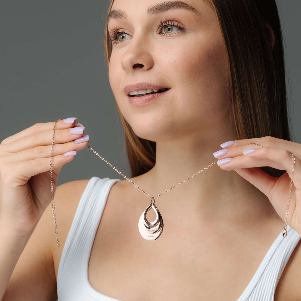 Model showcases the elegant Drop Name Necklace by Brother & Sisters, highlighting its sleek drop-shaped design.