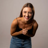 Thumbnail for Smiling woman in black top showcasing joy and happiness, perfect for promoting the Drop Photo Necklace by Brother & Sisters.