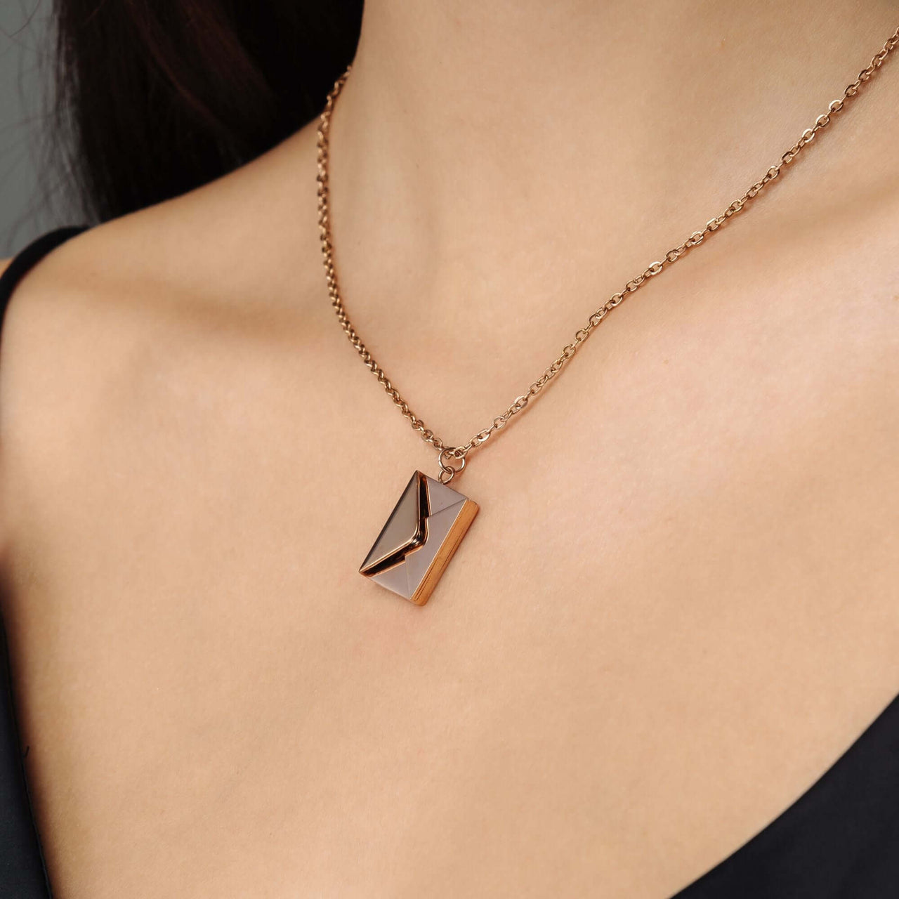 Envelope Name Necklace by Brother & Sisters showcasing a stylish, personalized design on a model's neck.