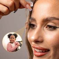 Thumbnail for Close-up of woman holding Family Photo Bracelet with a pendant photo of a smiling girl, by Brother & Sisters.