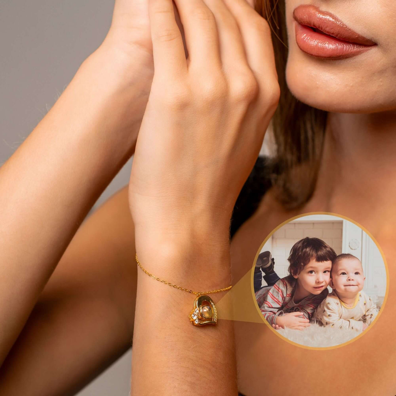 A close-up of a woman's wrist wearing the Family Photo Bracelet by Brother & Sisters, featuring a photo pendant of children.
