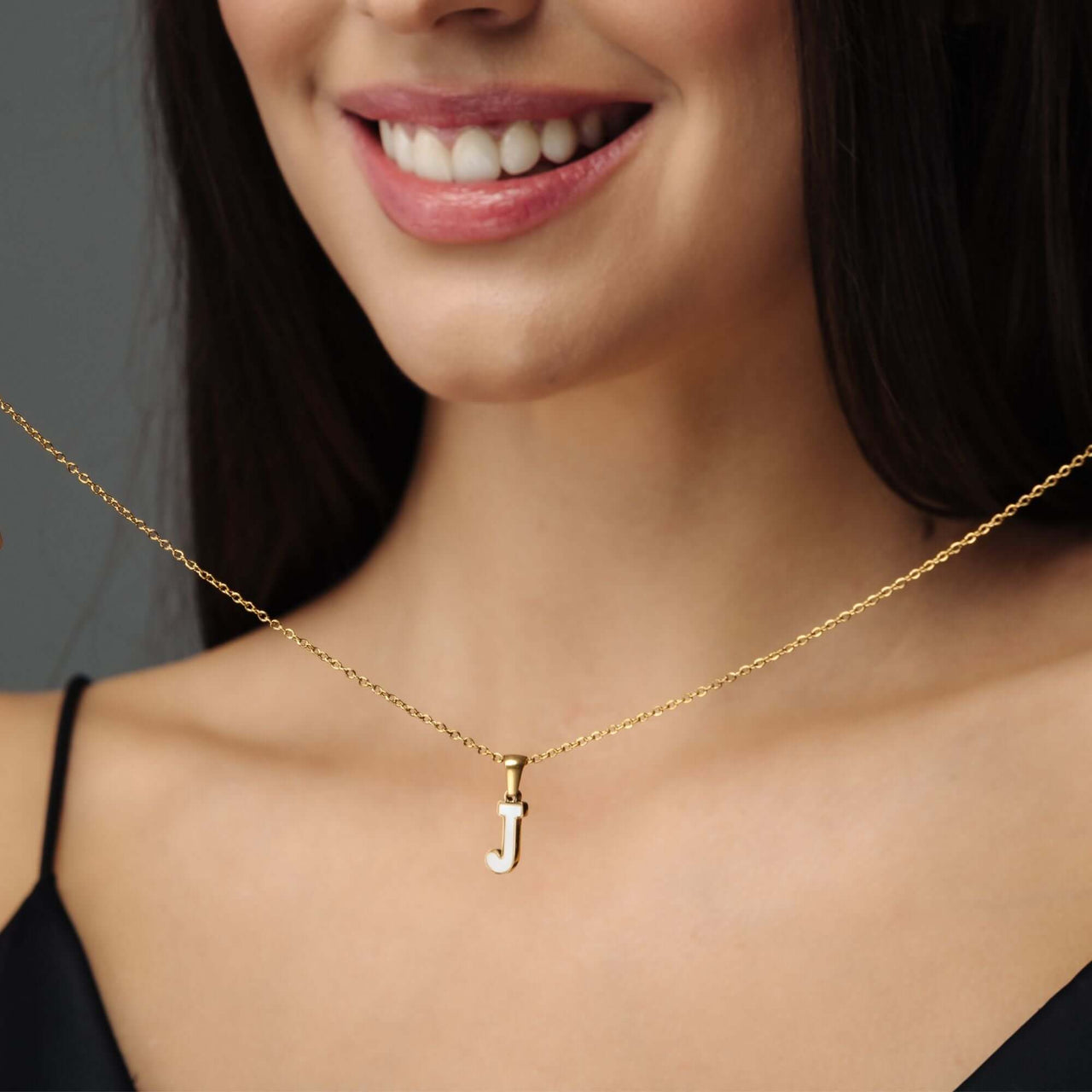 Hope Initial Necklace worn by a smiling woman showcasing elegant gold design and custom letter 'J' charm.