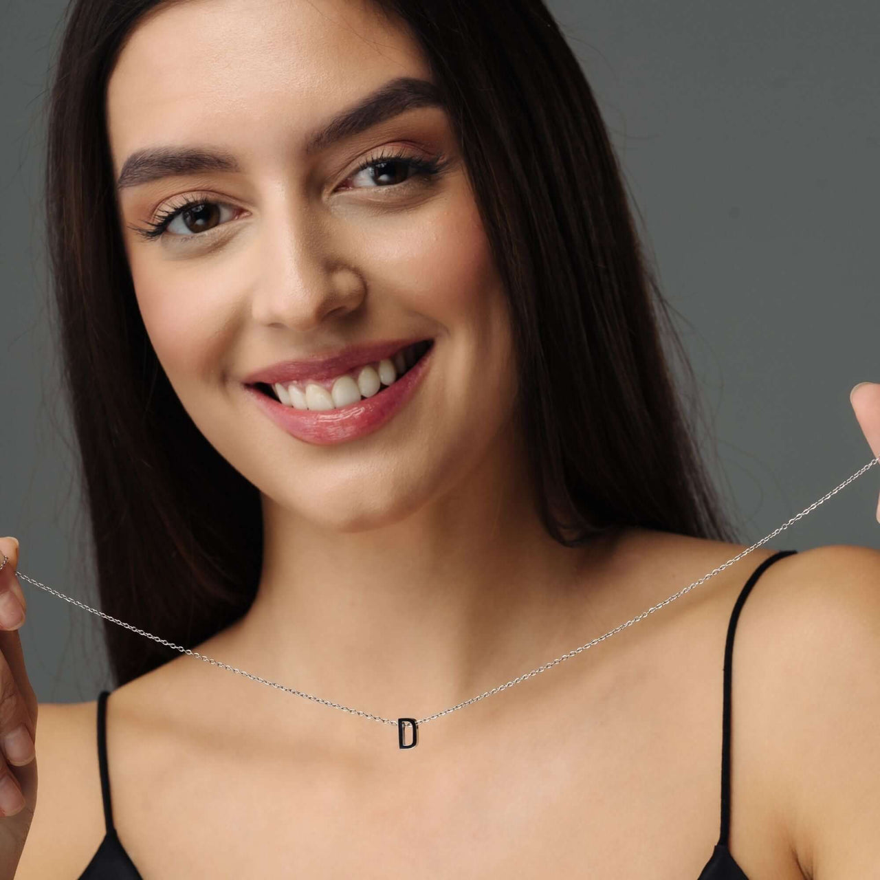 Iconic Initial Necklace showcasing a personalized 'D' initial, worn by a smiling woman, by Brother & Sisters.