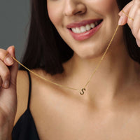Thumbnail for Model showcasing the Iconic Initial Necklace by Brother & Sisters, featuring a gold letter 'S' for personalized elegance.
