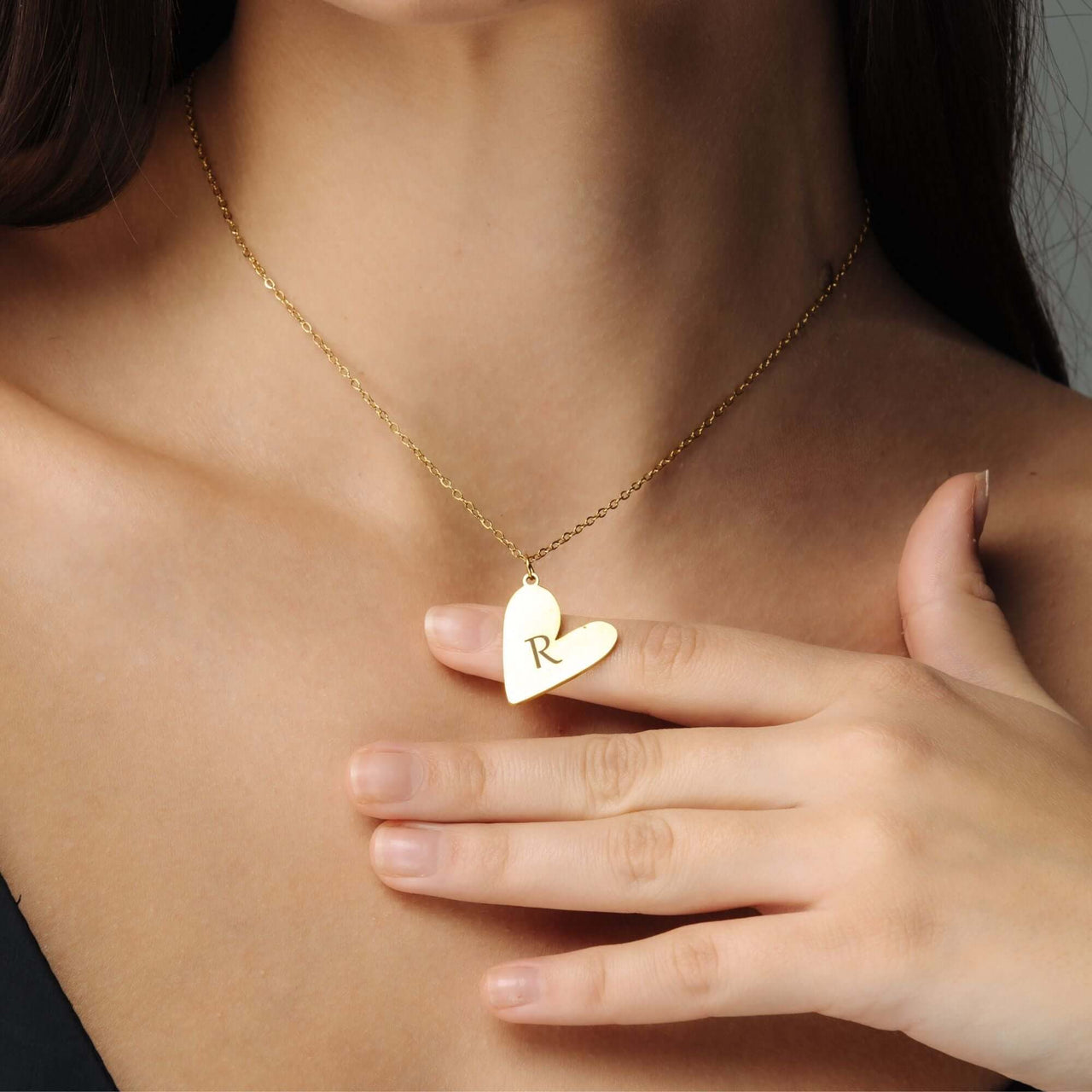Romantic Initial Necklace showcasing a gold heart pendant with 'R' worn on a woman's neck by Brother & Sisters.