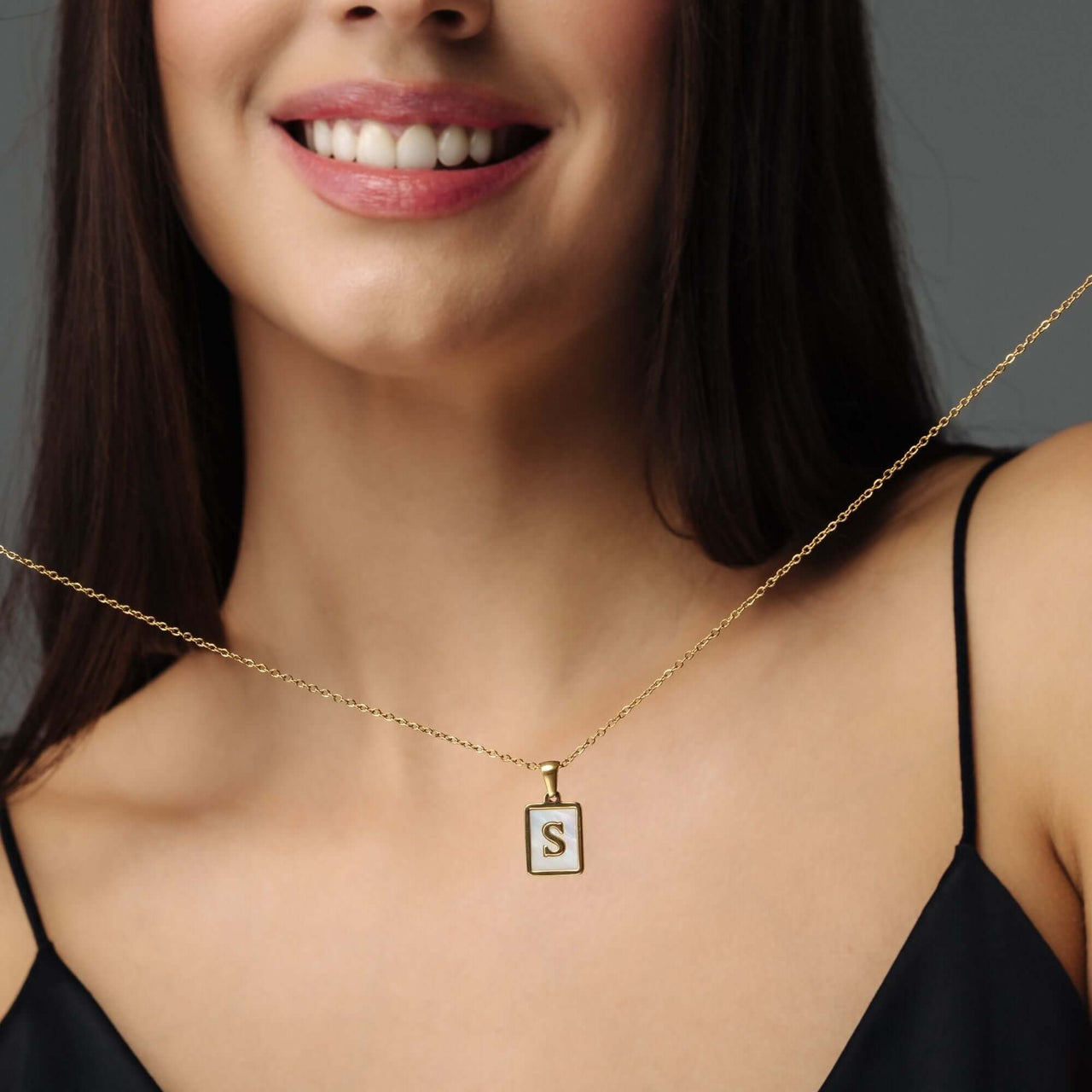 Happiness Initial Necklace displayed on a woman, personalized gold jewelry by Brother & Sisters with letter S.