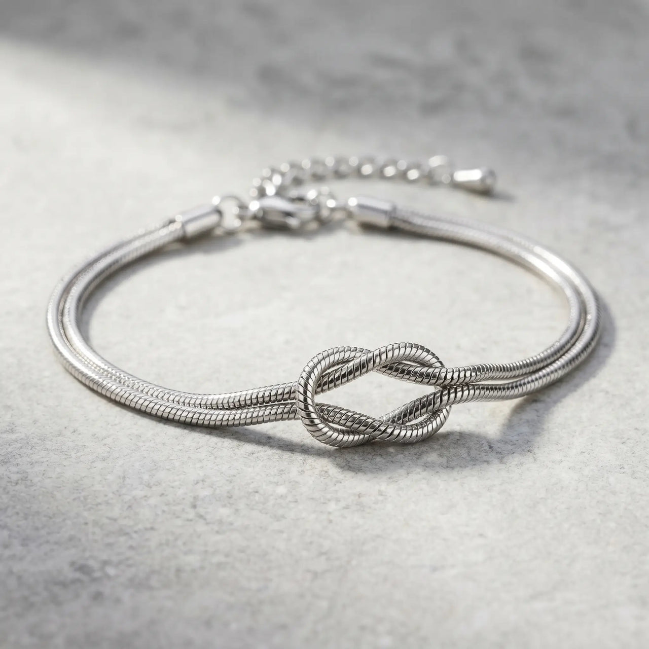 Knot Couple Bracelet silver macro detail flat on stone surface