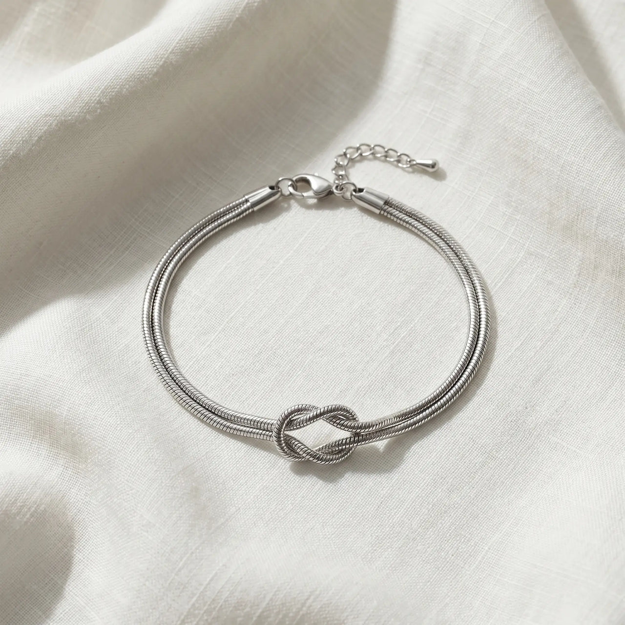 Lane B v2 Knot Couple Bracelet silver single bracelet flat-lay cool ivory linen architectural