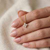 Thumbnail for Crystal Flower necklace held between feminine fingertips with natural nude manicure — refined dainty perfection scale reveal