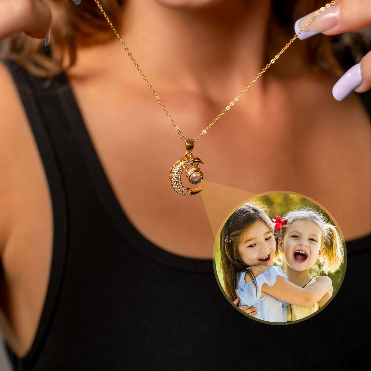 Lucky Moon Photo Necklace featuring a crescent moon charm projecting a photo of joyful children, by Brother & Sisters.