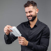 Thumbnail for Man smiling while opening a gift box, showcasing excitement for the Classic Photo Bracelet by Brother & Sisters.