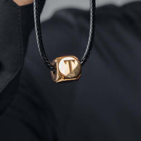 Thumbnail for Gold Cube Initial Necklace by Brother & Sisters featuring a personalized letter 'T' pendant on a black cord.