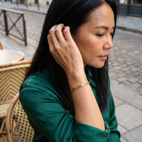 Thumbnail for Woman gently touching her Never Forget To Dream bracelet in gold | SKU: nftd-g