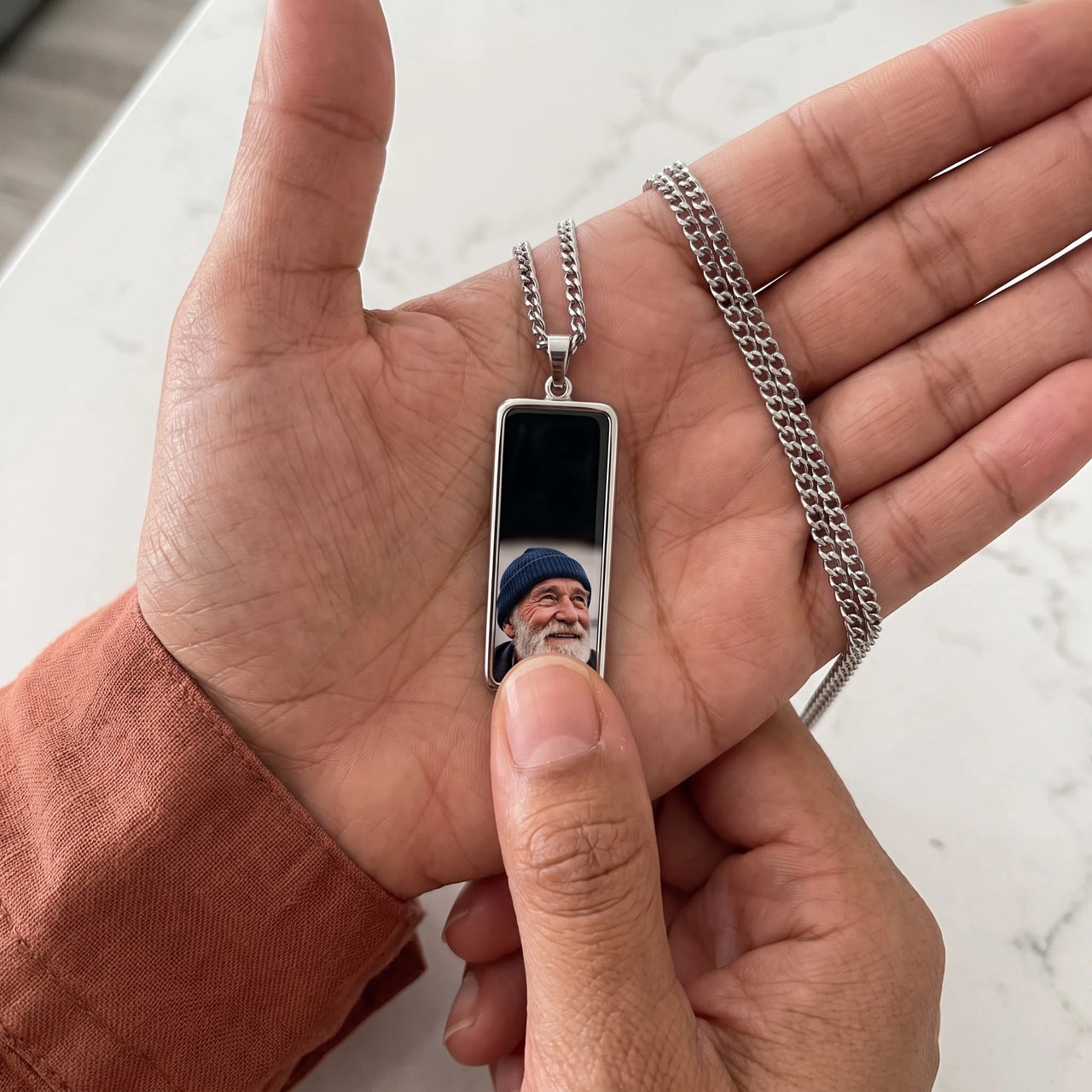 Thumb warming the silver bar pendant: the hidden photo appears under the thumb while the rest stays black | SKU: TPH-BARN-SILVER