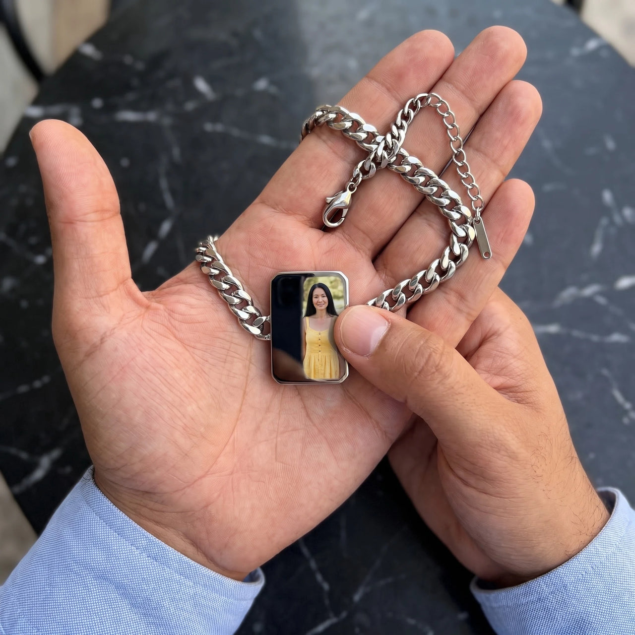 Thumb warming the silver cushion bracelet plate: the hidden photo appears under the thumb while the rest stays black | SKU: TPH-CUSB-SILVER