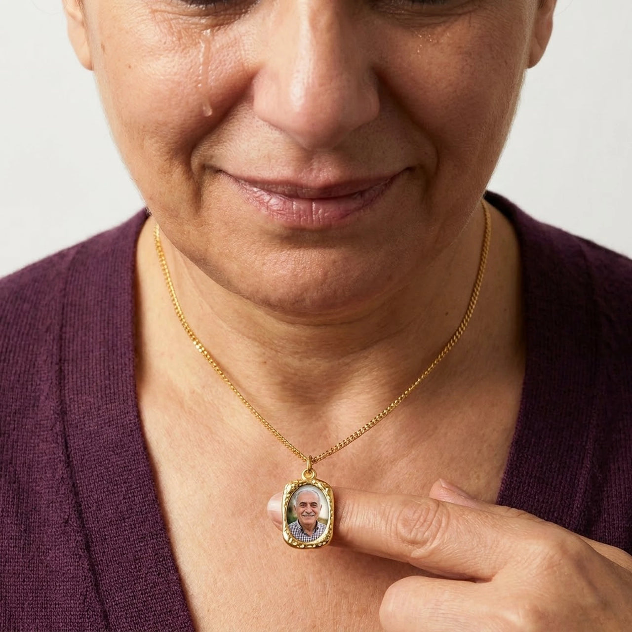 Woman moved as she looks at her late husband's photo in the gold oval necklace | SKU: TPH-OVLN-GOLD