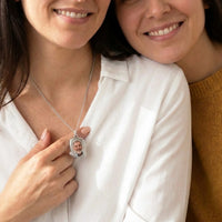 Thumbnail for Sister fastening the silver oval photo necklace with their late father's photo | SKU: TPH-OVLN-SILVER