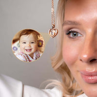 Thumbnail for Woman wearing Timeless Photo Necklace with heart-shaped pendant featuring a smiling baby photo, by Brother & Sisters.