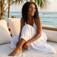 Thumbnail for Tiny Heart Drop Anklet worn by a woman with curly hair, enjoying the beach, showcasing its delicate design.