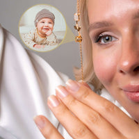 Thumbnail for A woman showcasing the Tulip Photo Bracelet by Brother & Sisters, holding a charm that displays a hidden photo.